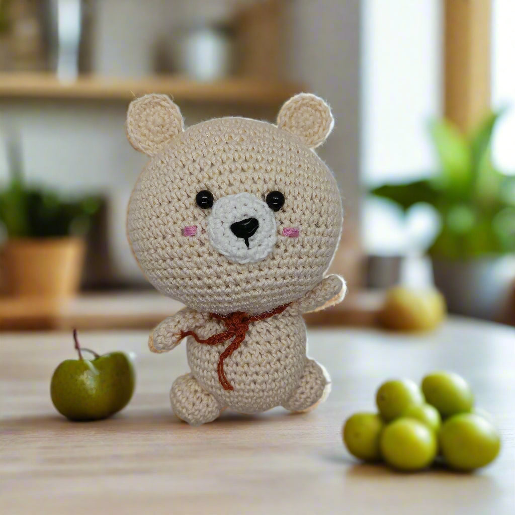 Crocheted bear toy with a brown muffler for kids