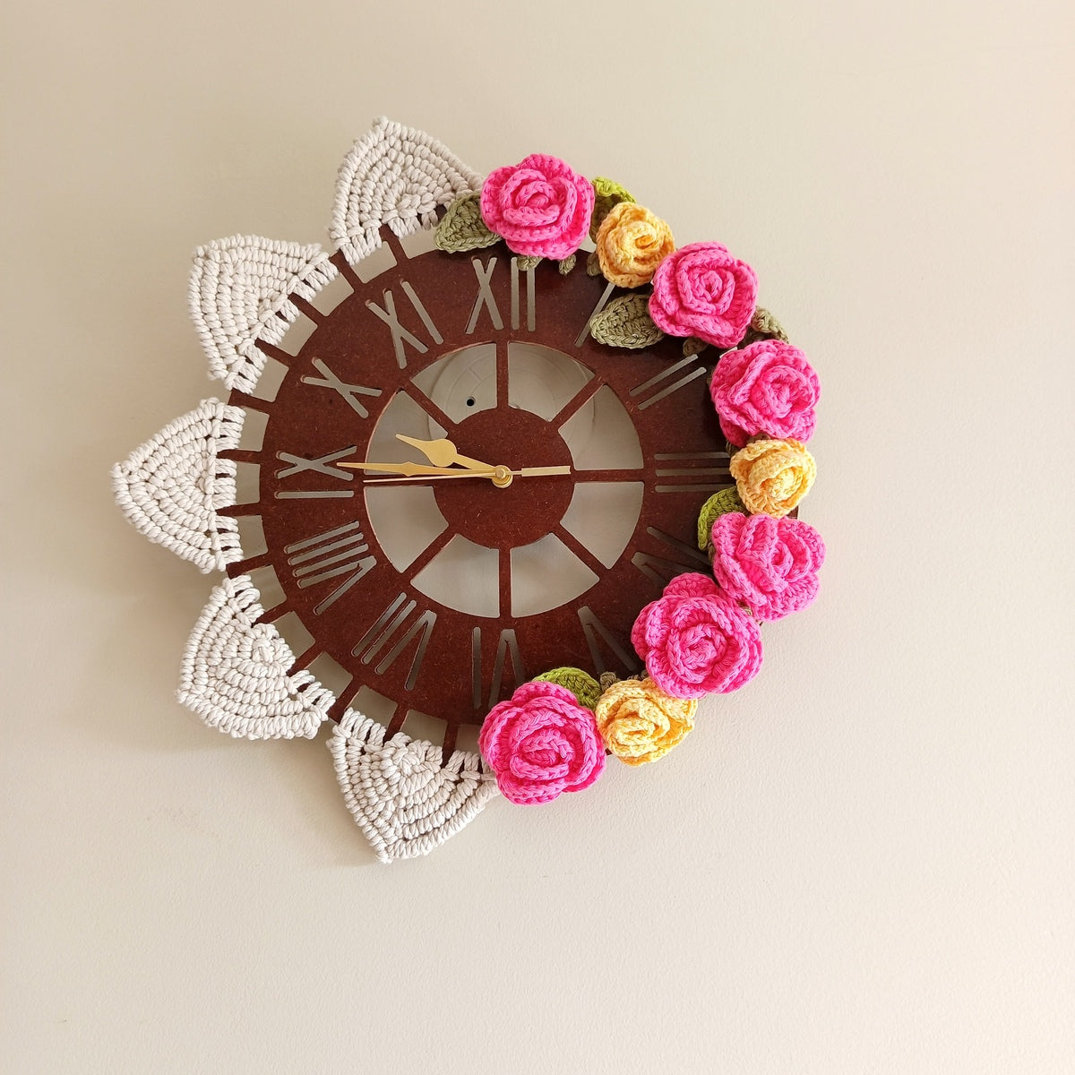 Decorative wall clock with floral designs on a plain background