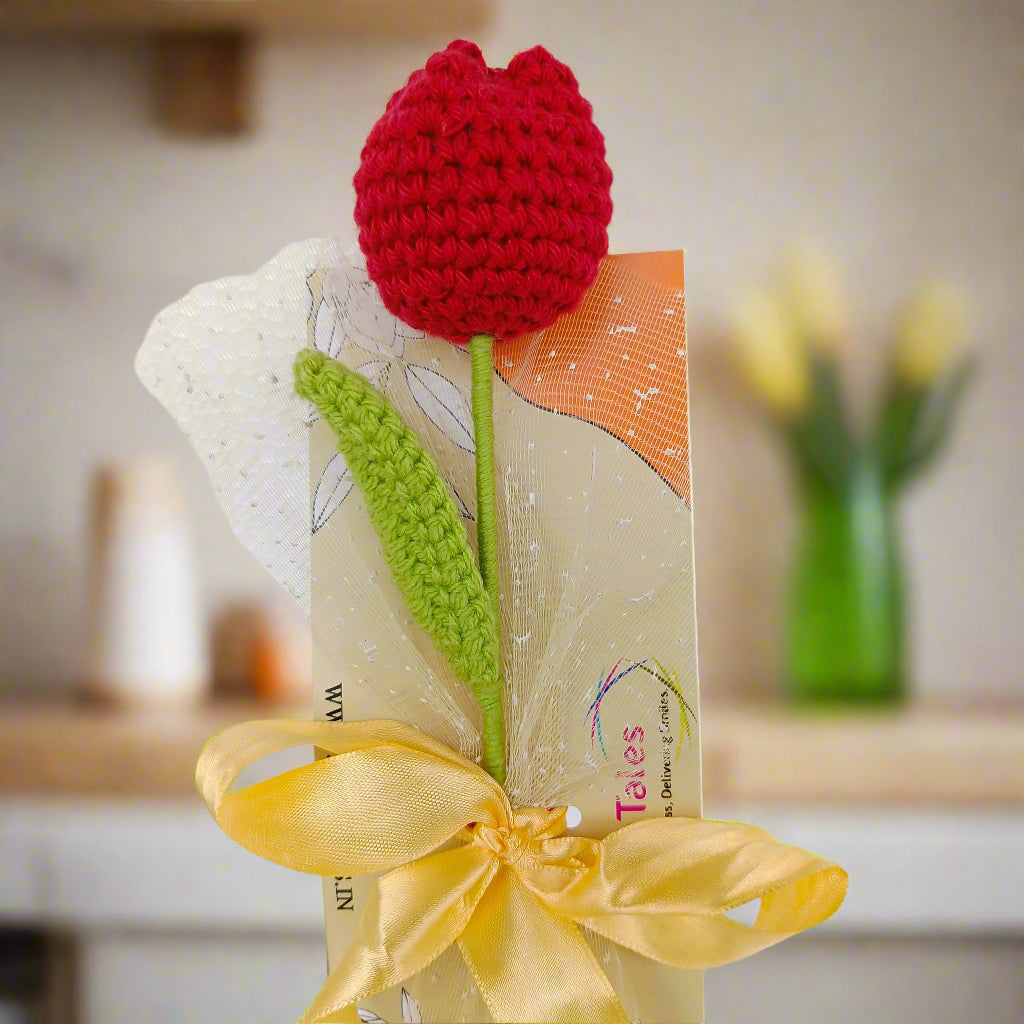 Crochet red tulip flower with green stem and yellow ribbon