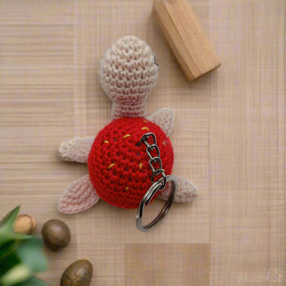 Crocheted Handmade turtle keychain with red shell and beige body 