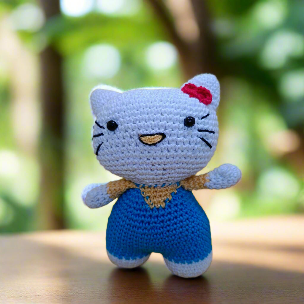 Crocheted Hello Kitty toy for kids with a red bow on a yellow