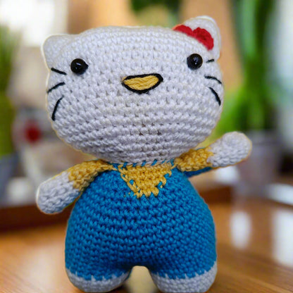 Crocheted Hello Kitty toy with a blue outfit and red bow