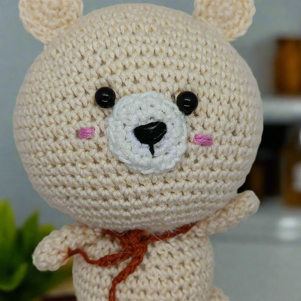 Crocheted bear toy with a white face and black eyes for kids