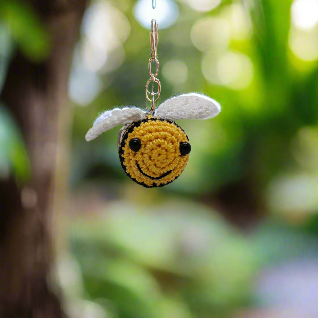 Crocheted bee keychain with yellow body and white wings 