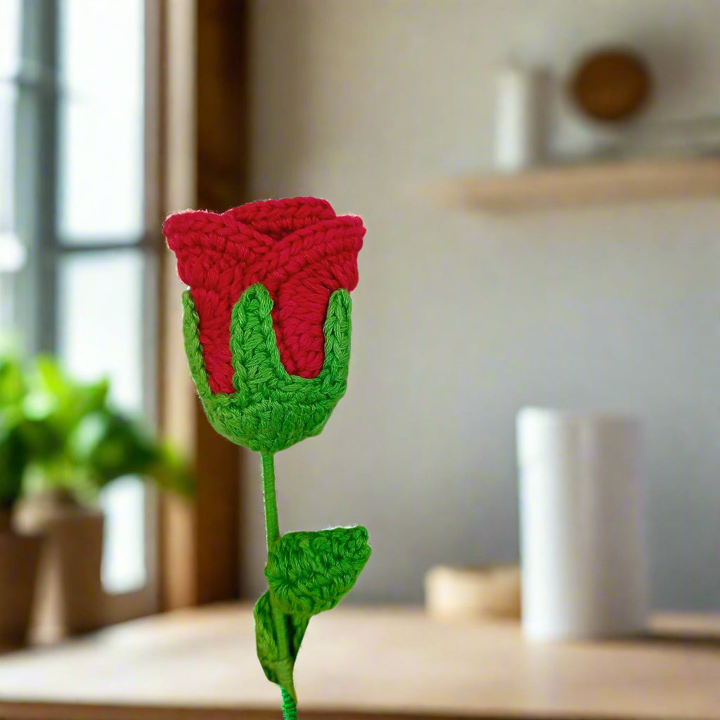 Crocheted red rose with green leaves for gift and decor