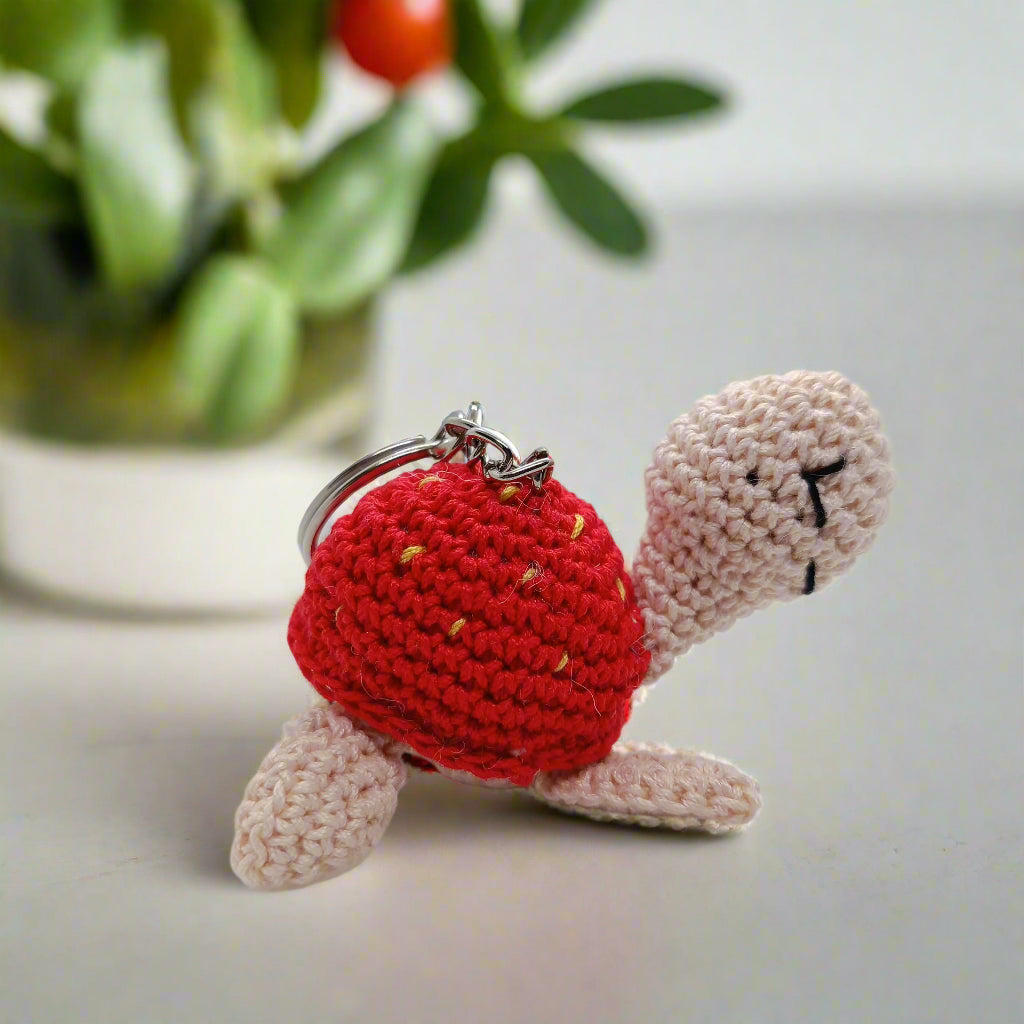 Crocheted soft turtle keychain with a red shell