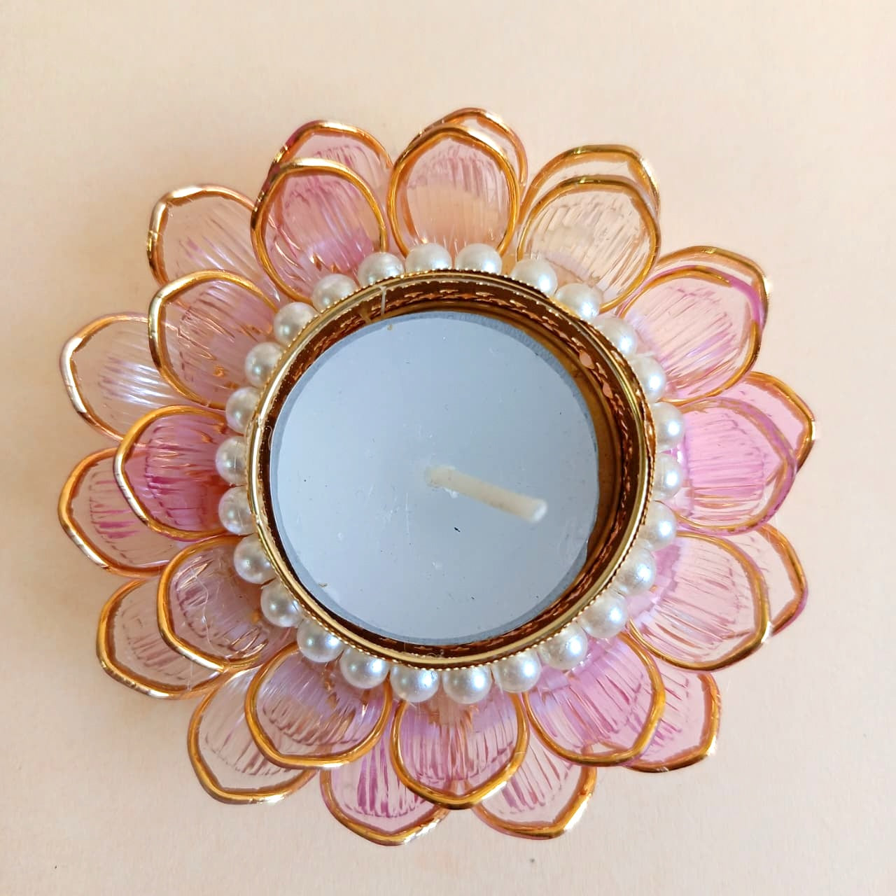 Decorative candle holder with pink petal-like design and pearl accents 